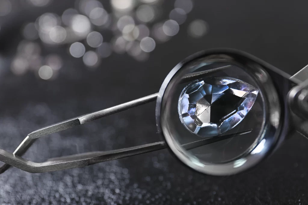 Diamante certificato e report gemmologico su banco di lavoro nel laboratorio orafo 18 Carati a Genova